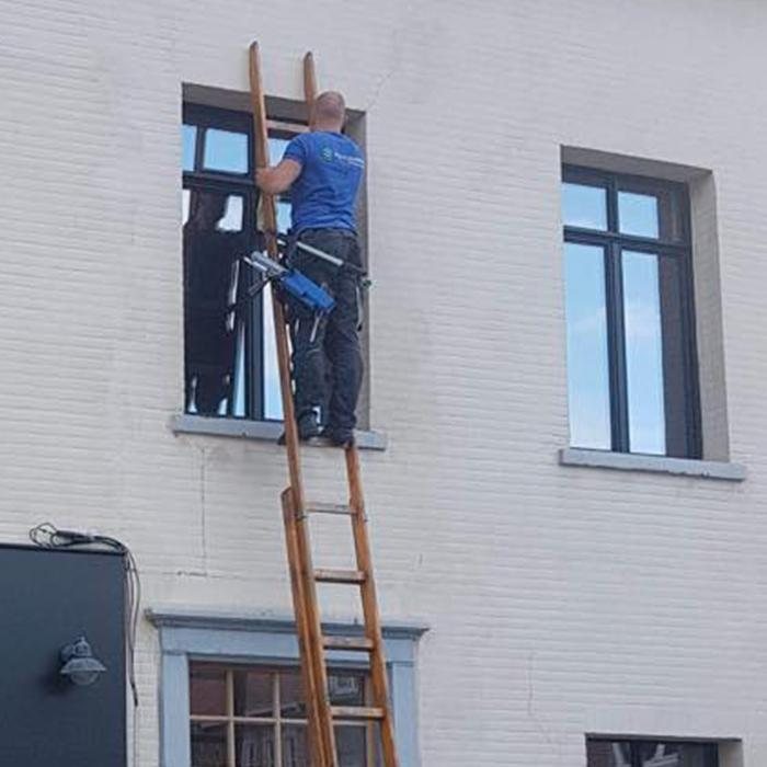 Ruitenwasser op een ladder tegen een gevel